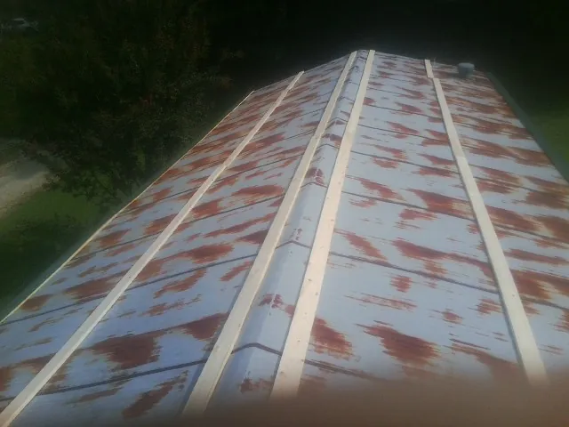 Rusted metal roof panels with new wood purlins before replacement — Storm Damage Roof Repair in Reedsville by Roofing Brothers