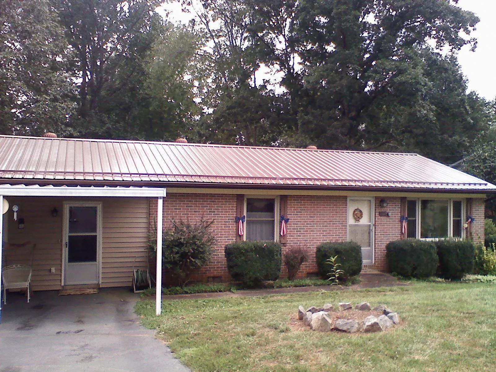 Bronze metal roof and carport on a brick ranch home — Roof Repair work by our crew in Reedsville